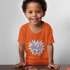 a smiling toddler playing a card game wearing an orange t-shirt with the Blue Nose Pit Bull design by OMG You're Home on the front in full vibrant color