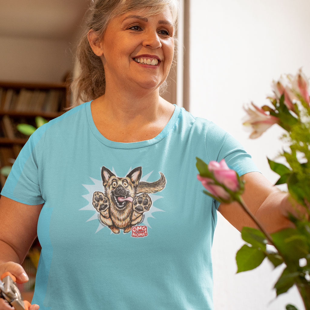 a smiling woman wearing a teal Next Level Womens Triblend shirt featuring the OMG You're Home German Shepherd dog design on the front in full color. 